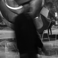 Homme passant devant une statue